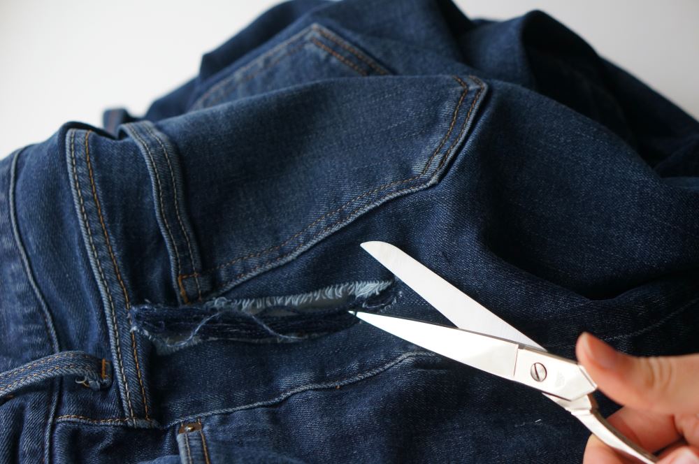 jeans fabric ripped out with scissors showing